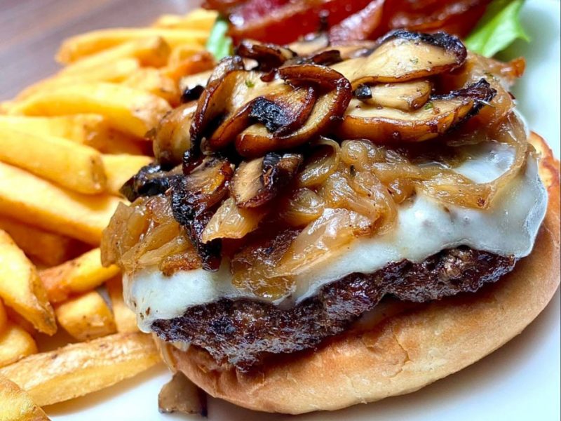 Tundra Pub burger with mushrooms, cheese, caramelized onions and french fries